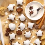 Finished gingerbread protein balls drizzled with coconut butter, styled on a baking sheet with cloves and ginger cookies, ready to enjoy