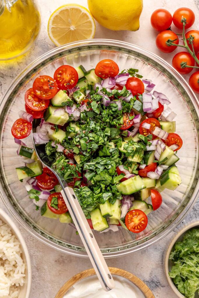 Chopped cucumber, cherry tomatoes, red onion, and fresh dill for Greek cucumber salad.
