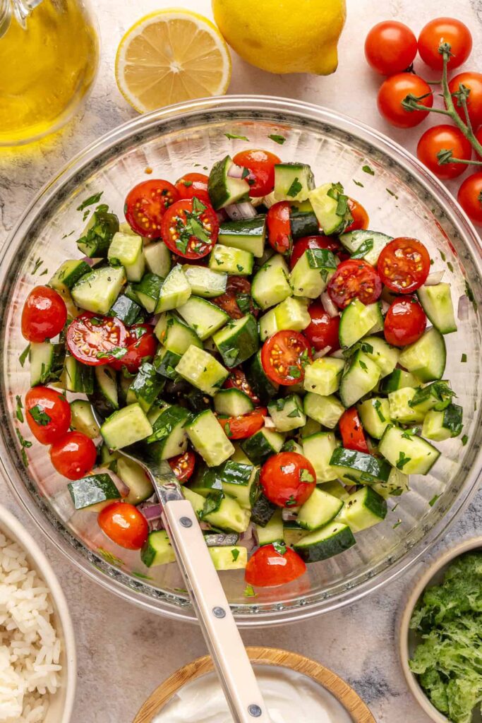 Fresh cucumber-tomato salad tossed with olive oil, red wine vinegar, and herbs.
