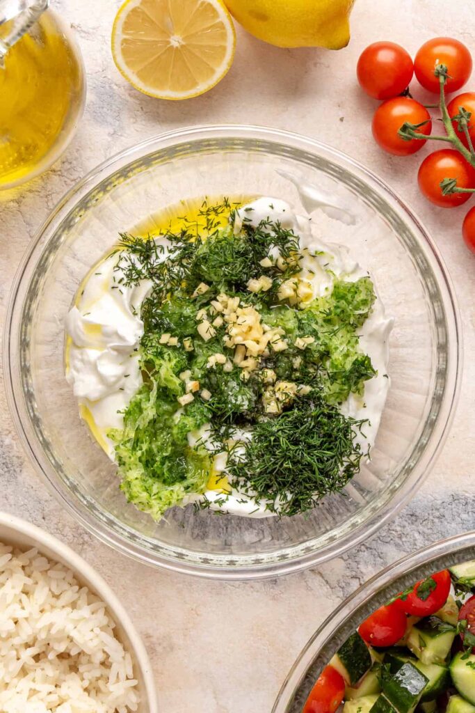 Greek yogurt, grated cucumber, garlic, dill, and lemon assembled for homemade tzatziki.