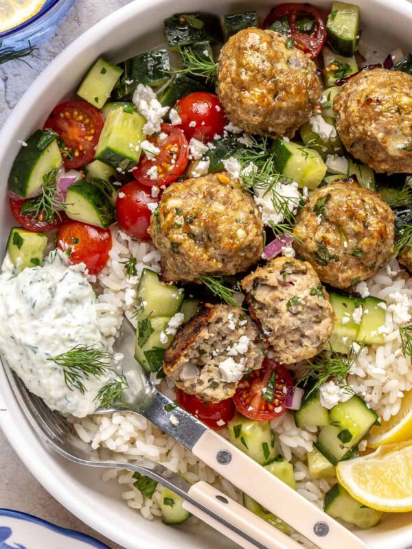 Juicy Greek turkey meatballs served over rice with tzatziki and cucumber-tomato salad.