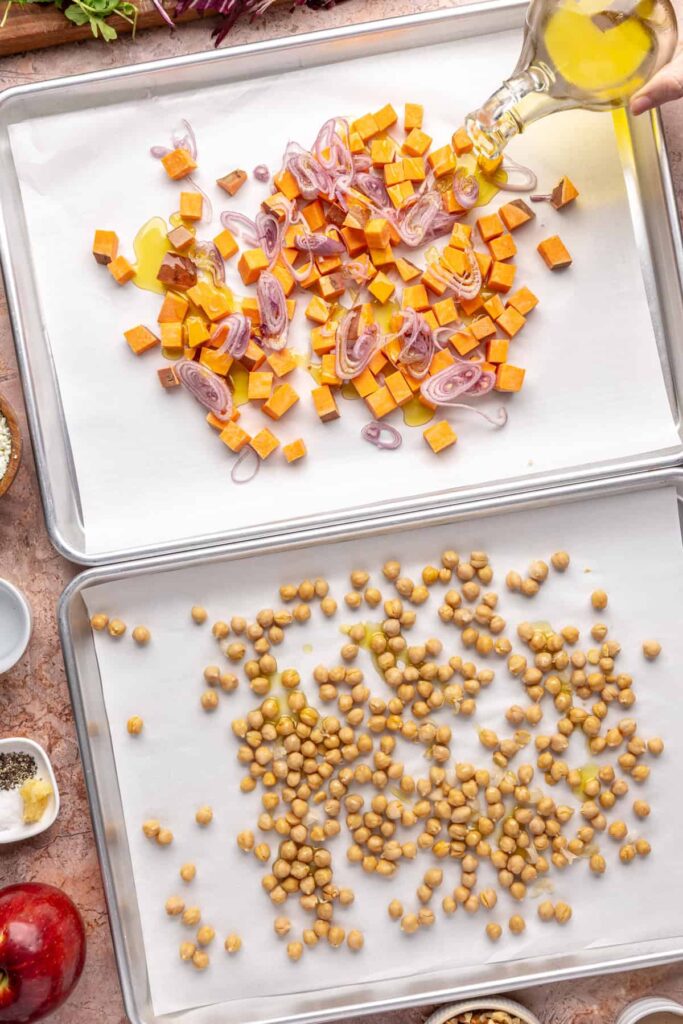 Harissa-seasoned sweet potatoes and shallots on baking sheet for harvest salad