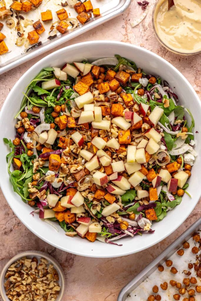 Assembling harvest salad with apples, walnuts, and feta