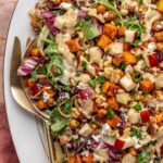 ully assembled harvest salad topped with roasted vegetables and maple tahini dressing
