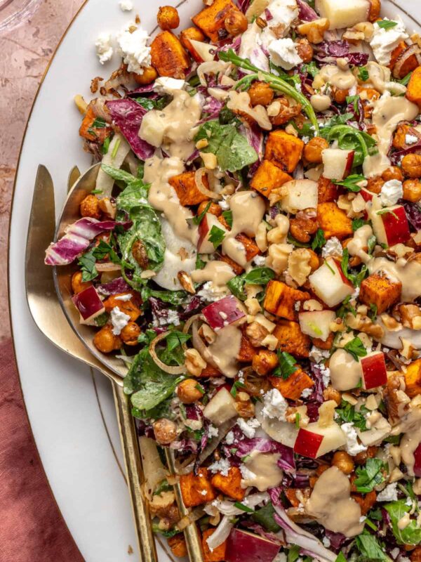 ully assembled harvest salad topped with roasted vegetables and maple tahini dressing
