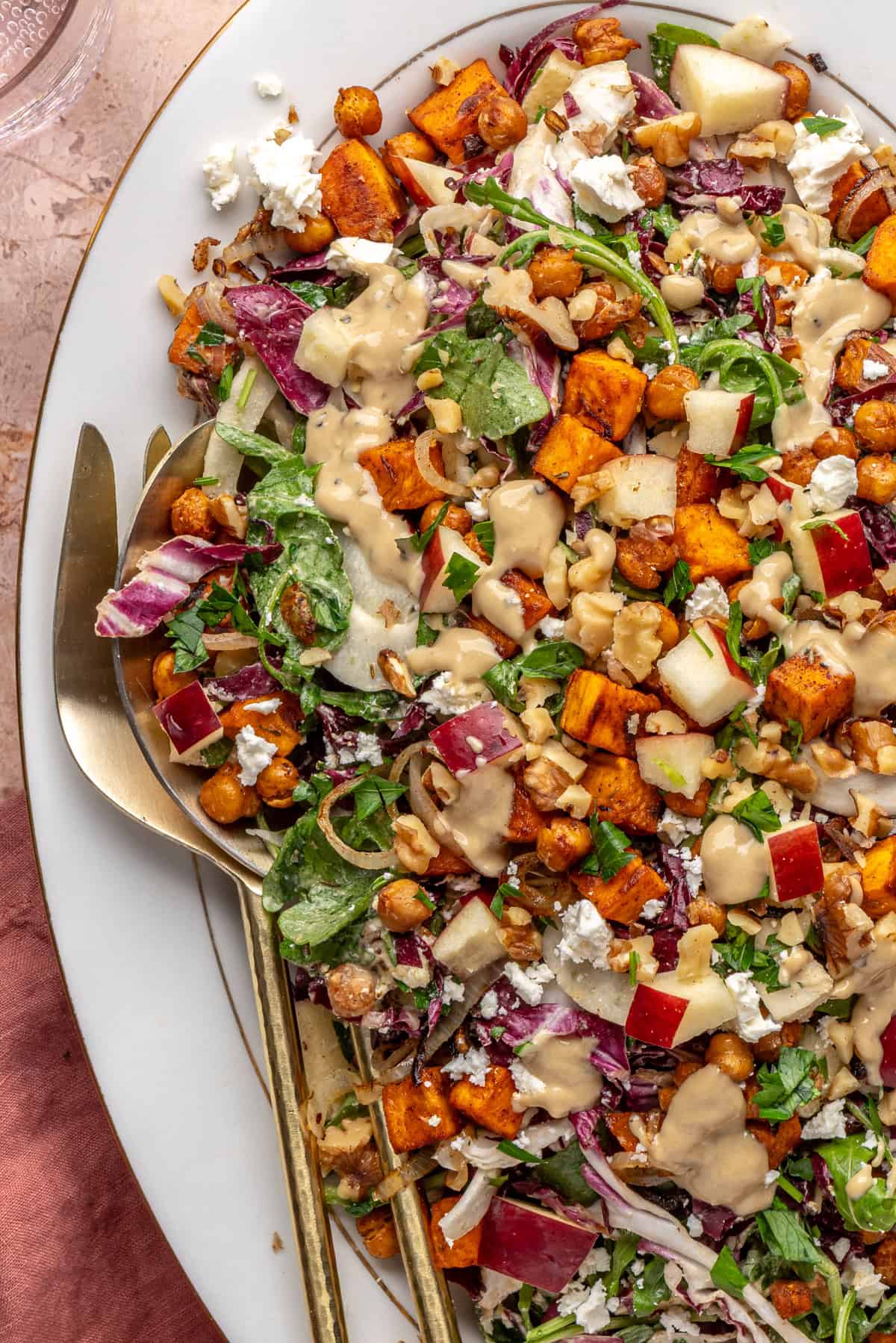 ully assembled harvest salad topped with roasted vegetables and maple tahini dressing