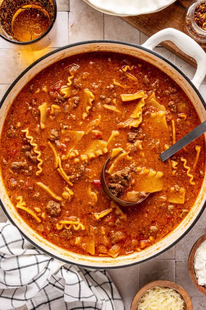 One-pot lasagna soup simmering with ground beef, marinara, and gluten-free lasagna noodles.