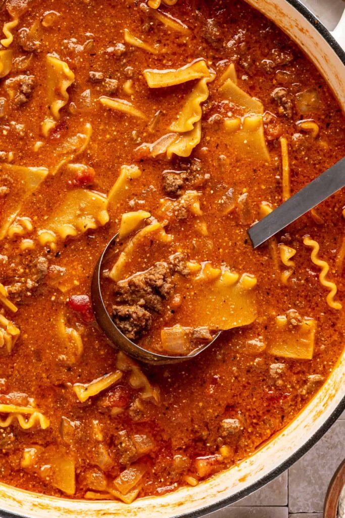 Close-up of creamy lasagna soup with broken lasagna noodles, ground beef, and ricotta.