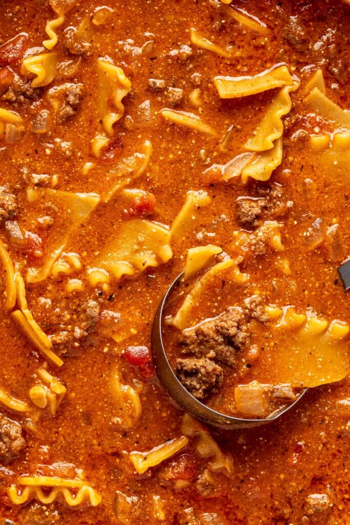 Close-up of creamy lasagna soup with broken lasagna noodles, ground beef, and ricotta.