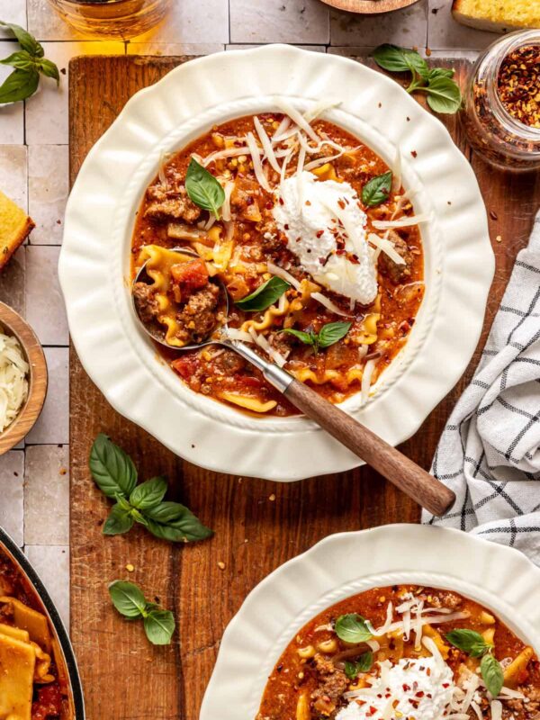 High-protein lasagna soup in a bowl topped with dairy-free ricotta, basil, and chili flakes