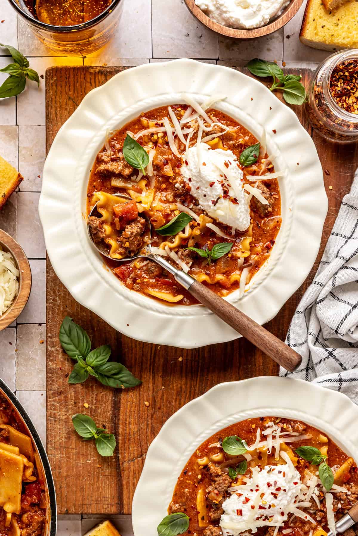 High-protein lasagna soup in a bowl topped with dairy-free ricotta, basil, and chili flakes