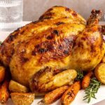 Plated Citrus Maple Chicken with crispy skin, roasted vegetables, and fresh herb garnish