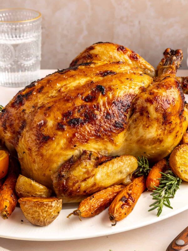 Plated Citrus Maple Chicken with crispy skin, roasted vegetables, and fresh herb garnish