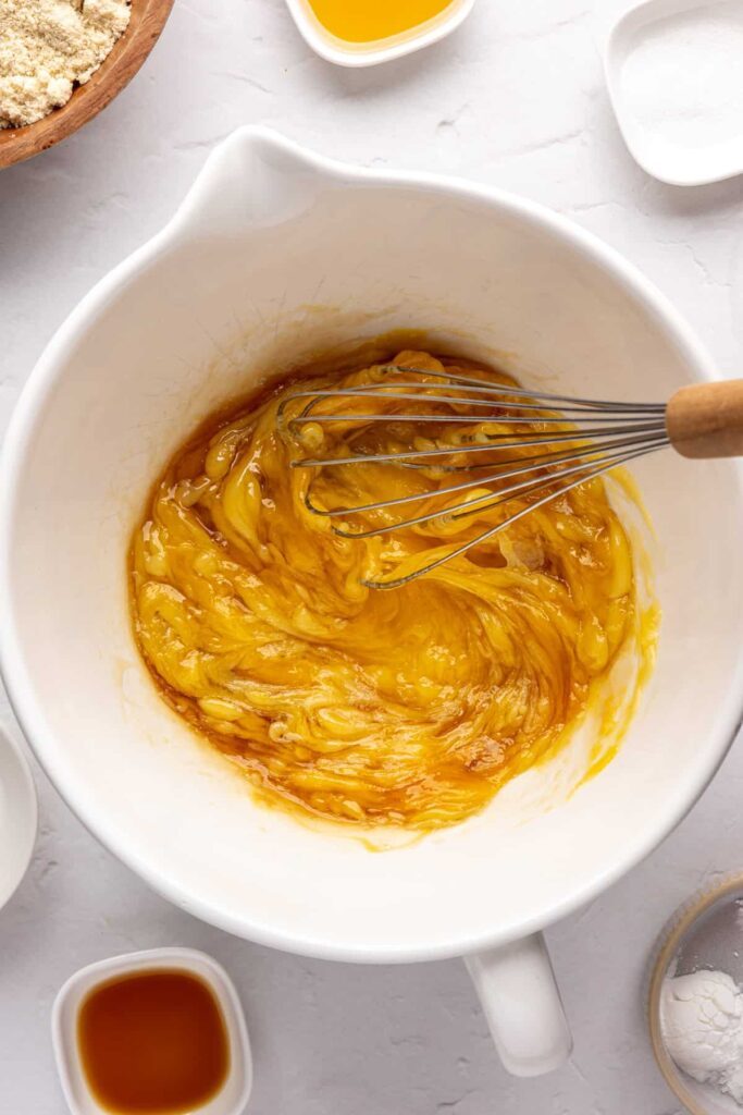 whisking together wet ingredients in a bowl for healthy Christmas Sugar Cookies
