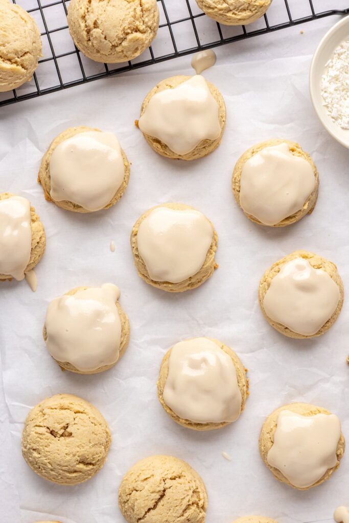 iced Christmas Sugar Cookies on parchment paper and a baking sheet