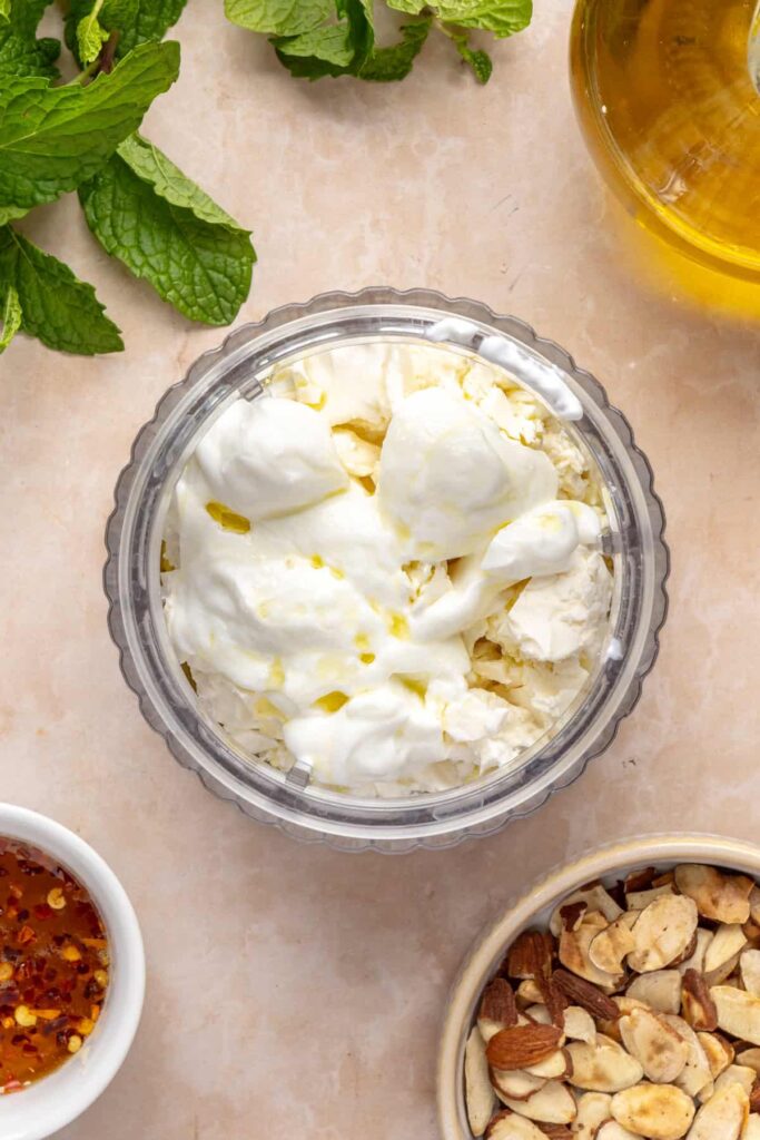 Blender with feta, yogurt, olive oil, and garlic for whipped feta on roasted sweet potatoes