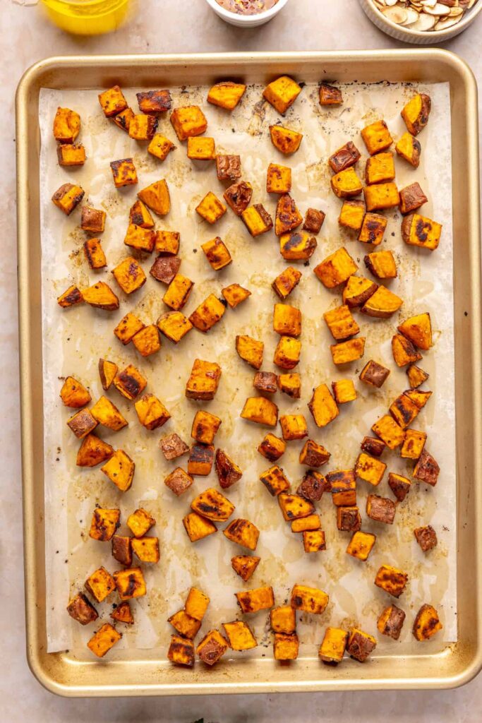 Golden roasted sweet potato cubes with crispy edges on a baking sheet