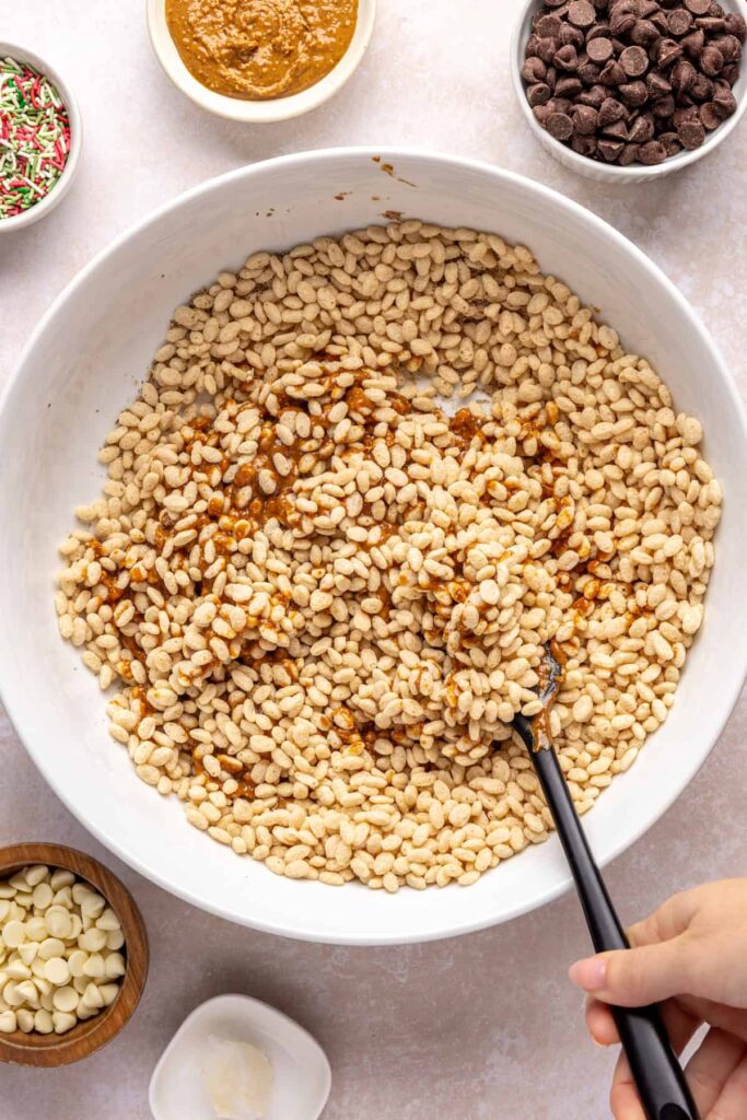 Mixing the peanut butter mixture with brown rice cereal to make salted peanut butter bars base