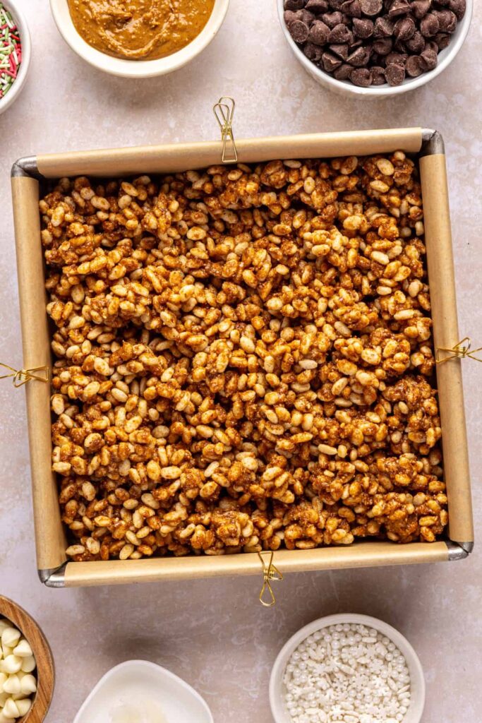 Base layer for salted peanut butter bar in an 8x8 parchment-lined pan