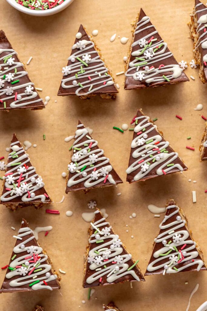 Christmas tree-shaped salted peanut butter bars with white chocolate drizzle and sprinkles.