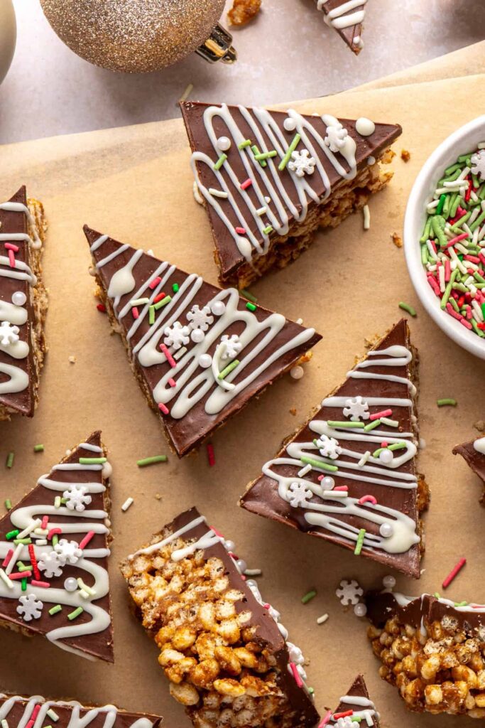 close-up of finished salted peanut butter bars on a parchment-lined wooden board with a bowl of peanut butter nearby