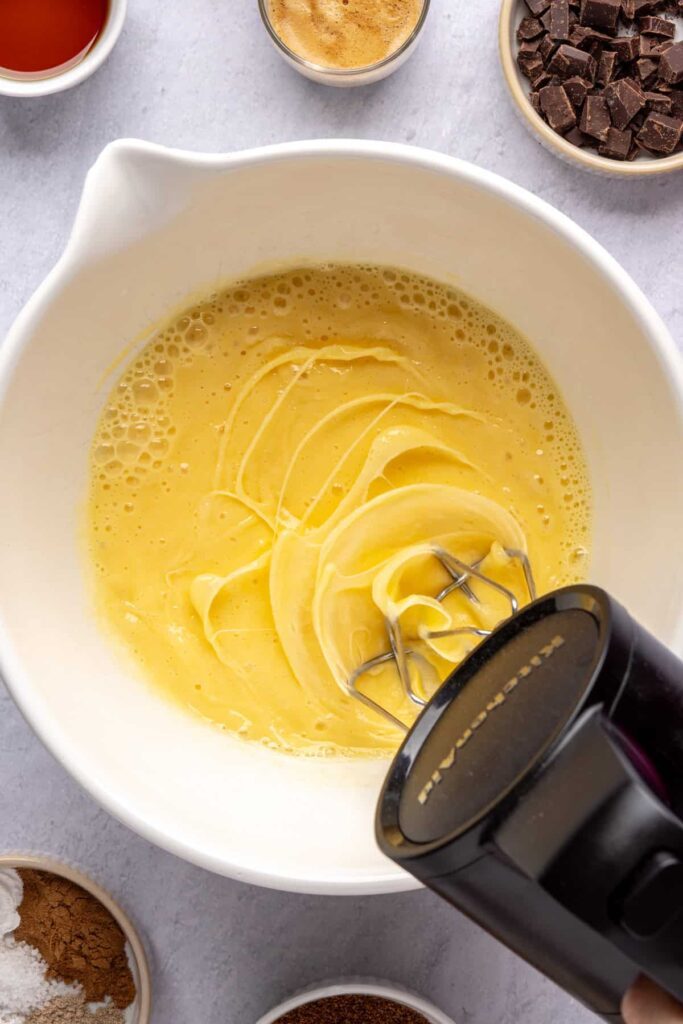 Mixing eggs and avocado oil until pale and fluffy for the pumpkin spice chocolate loaf batter.