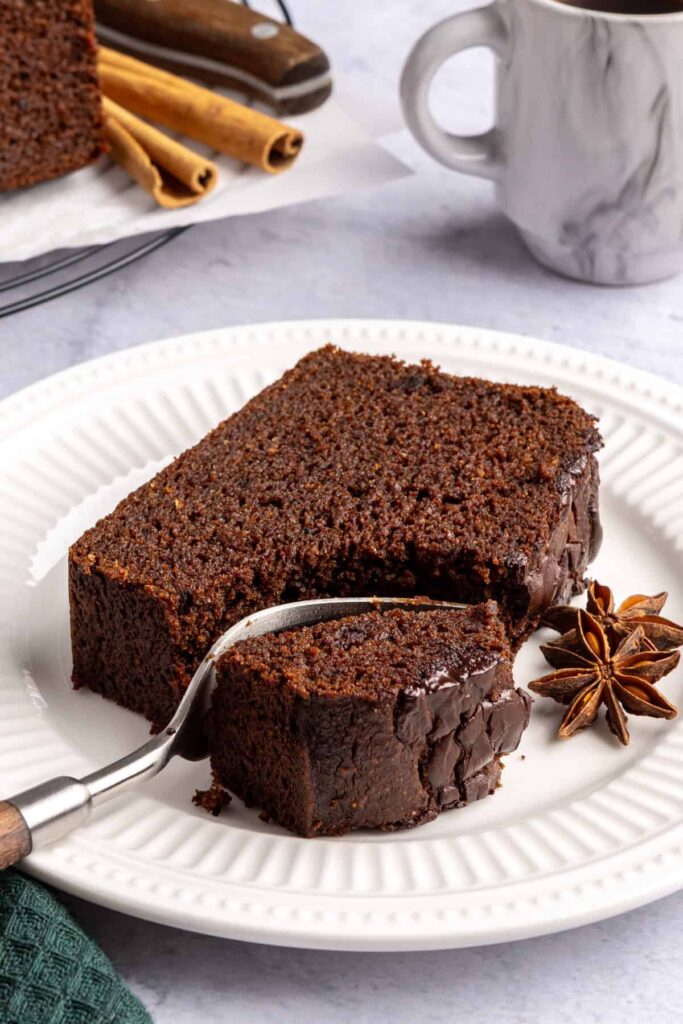 Pumpkin spice chocolate loaf slice with a bite taken out and a fork beside it, cozy fall recipe.