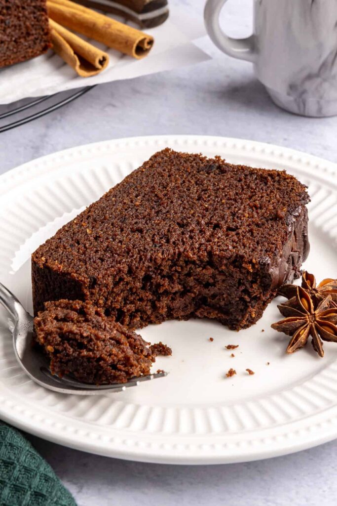 Pumpkin spice chocolate loaf slice with a bite taken out and a fork beside it, cozy fall recipe.