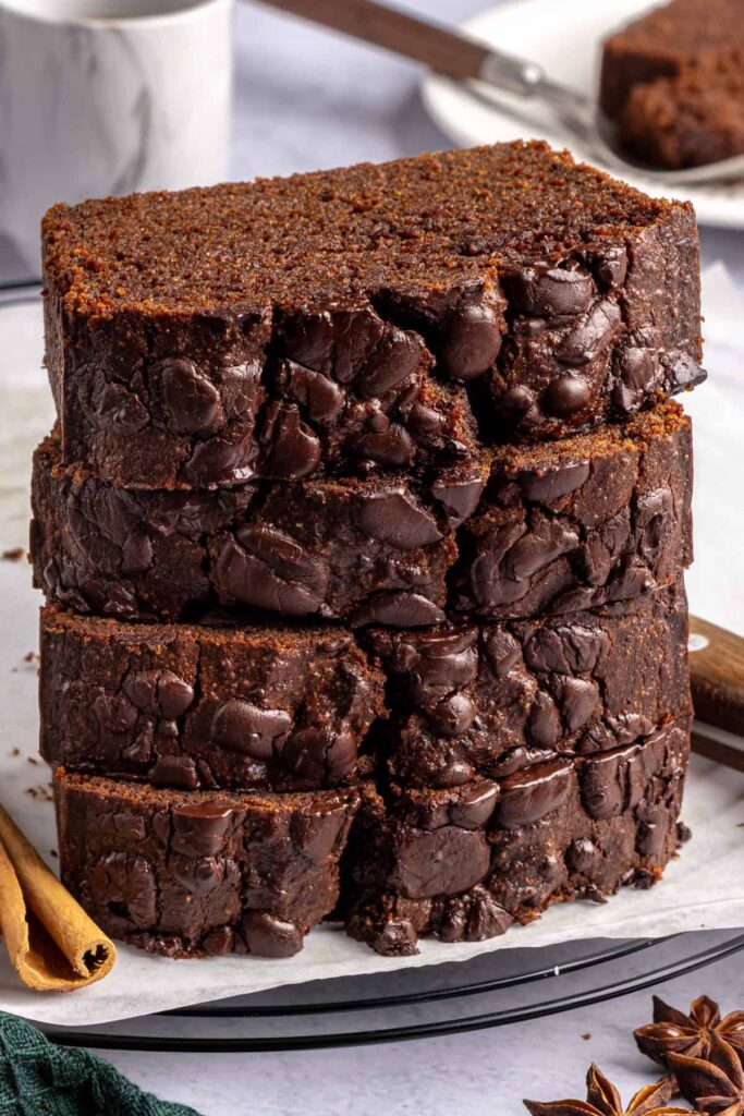 Stacked slices of pumpkin spice chocolate loaf showing the moist, chocolatey texture.