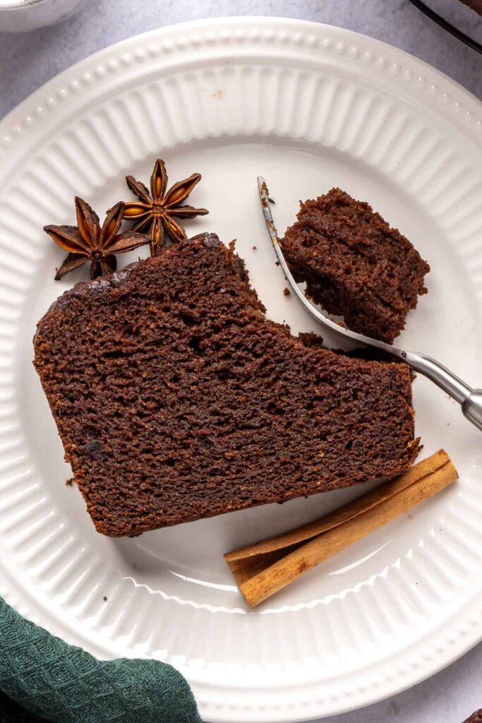 Pumpkin spice chocolate loaf slice with a bite taken out and a fork beside it, cozy fall recipe.