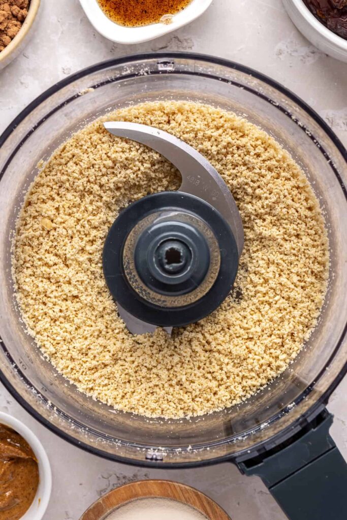 Finely ground cashews pulsed in a food processor for no-bake protein brownie bites