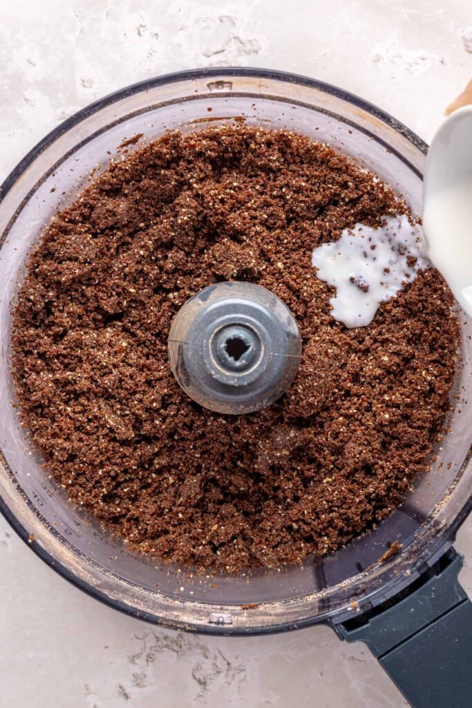 Adding a splash of milk to help the no-bake brownie bite dough bind together