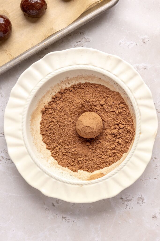 Protein brownie bites being rolled in cacao powder