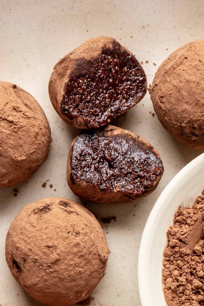 Protein brownie bite with a bite taken out, showing fudgy chocolate interior