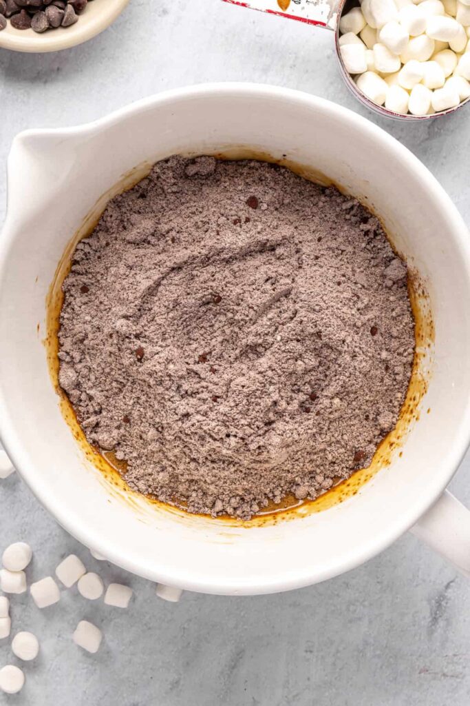 overhead shot of large mixing bowl with dry ingredients poured on top of the wet ingredients for hot cocoa cookies