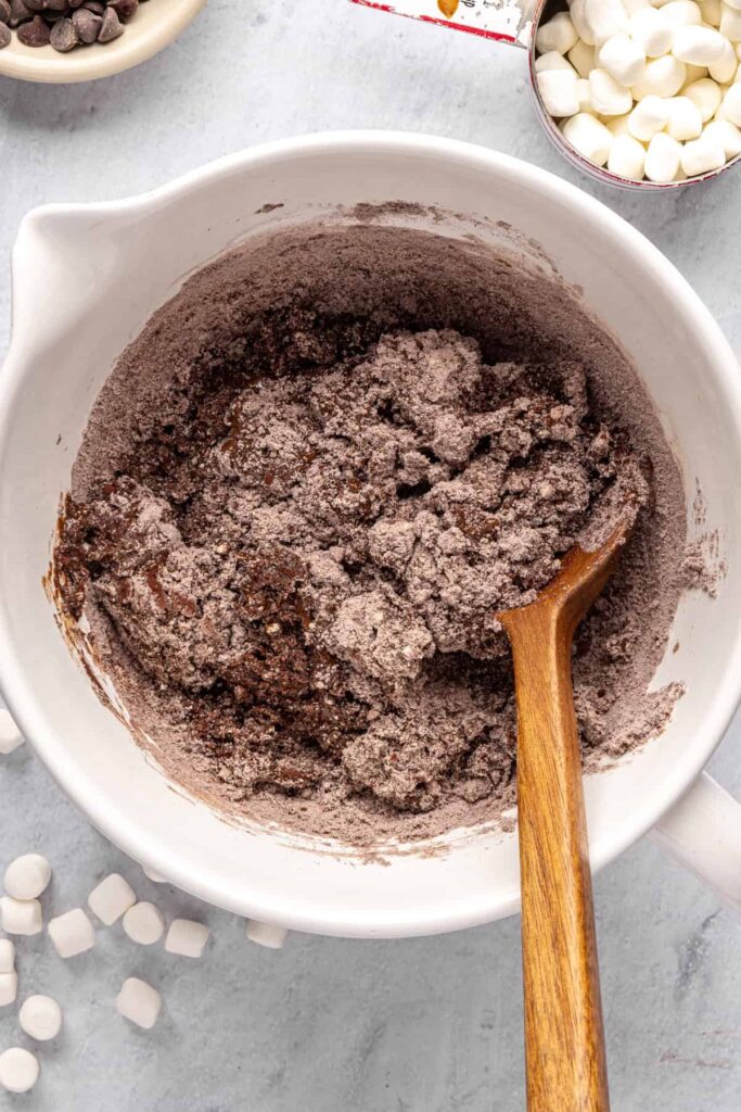 Combining wet and dry ingredients to form hot cocoa cookie dough