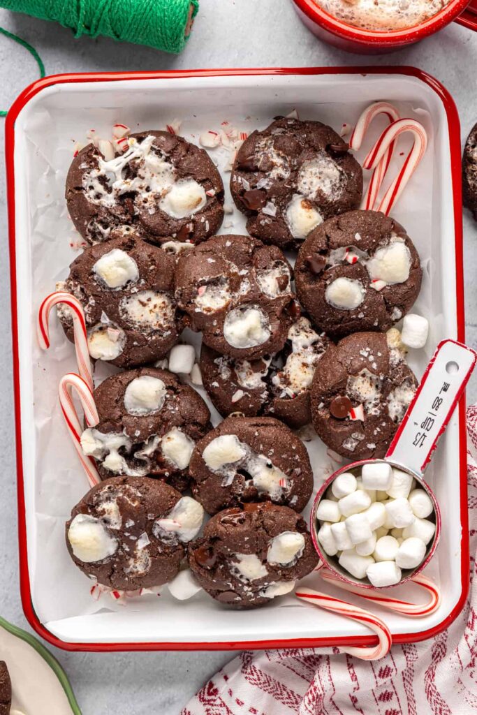 Holiday hot cocoa cookies arranged with candy canes on a festive tray