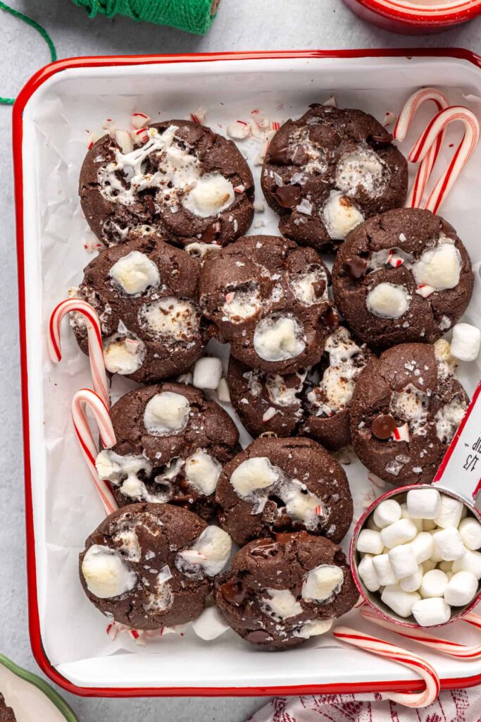 Holiday hot cocoa cookies arranged with candy canes on a festive tray