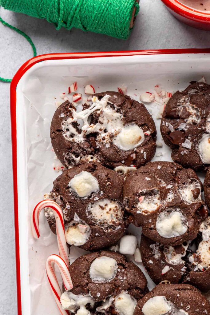 Holiday hot cocoa cookies arranged with candy canes on a festive tray
