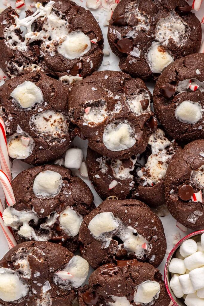 close-up of holiday hot cocoa cookies arranged with candy canes on a festive tray