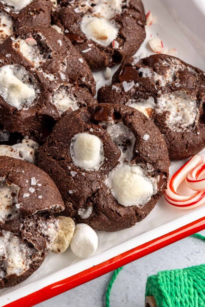 close-up of holiday hot cocoa cookies arranged with candy canes on a festive tray
