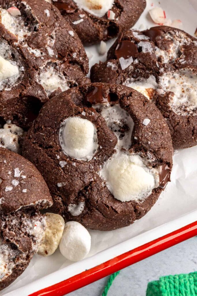 close-up of holiday hot cocoa cookies arranged with candy canes on a festive tray
