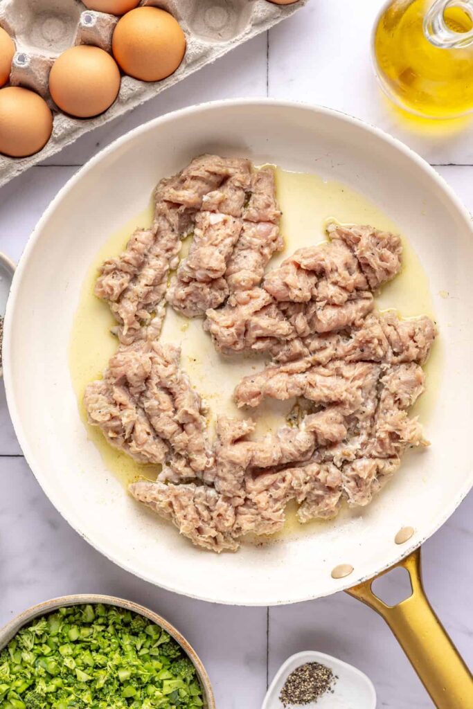 Italian chicken sausage cooking in skillet for Chicken & Veggie Egg Bake