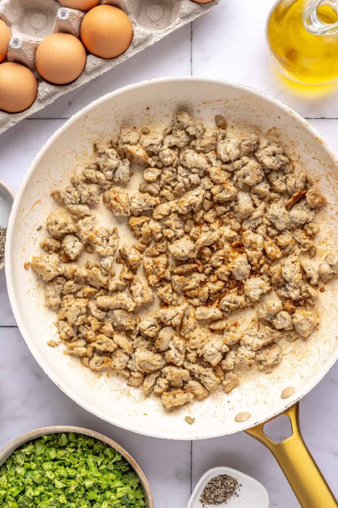 Italian chicken sausage cooking in skillet for Chicken & Veggie Egg Bake