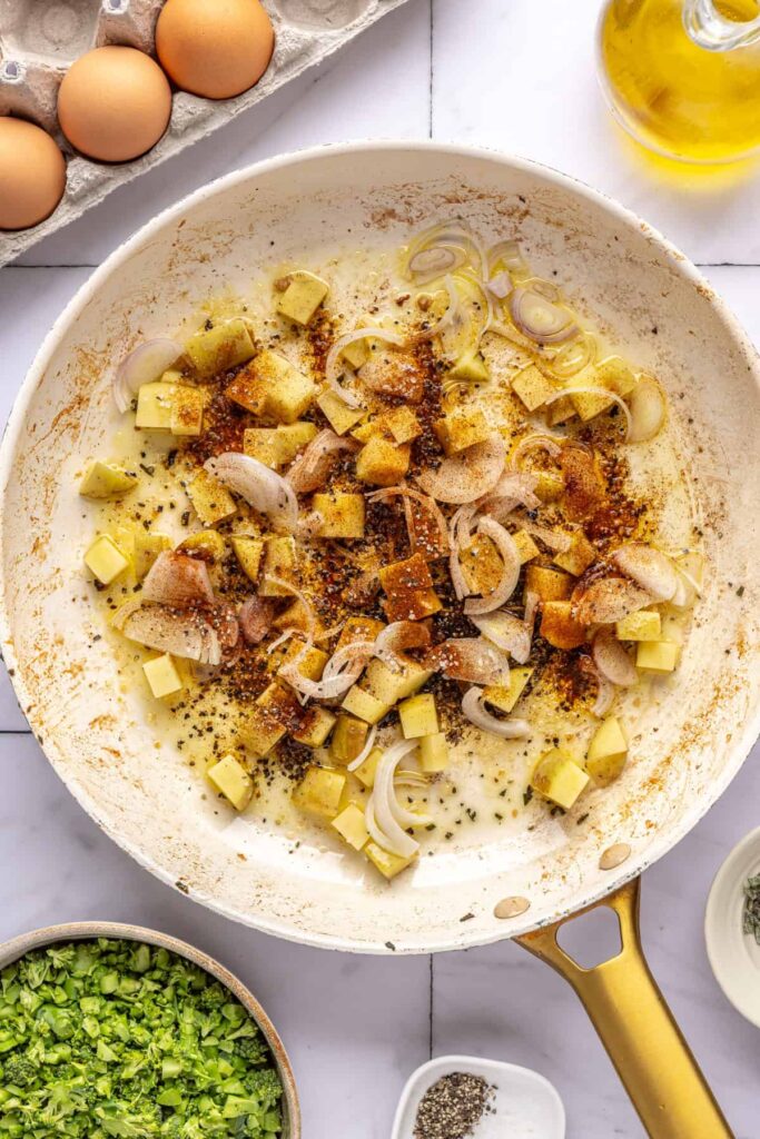 Veggies sautéing in skillet with seasonings for egg bake