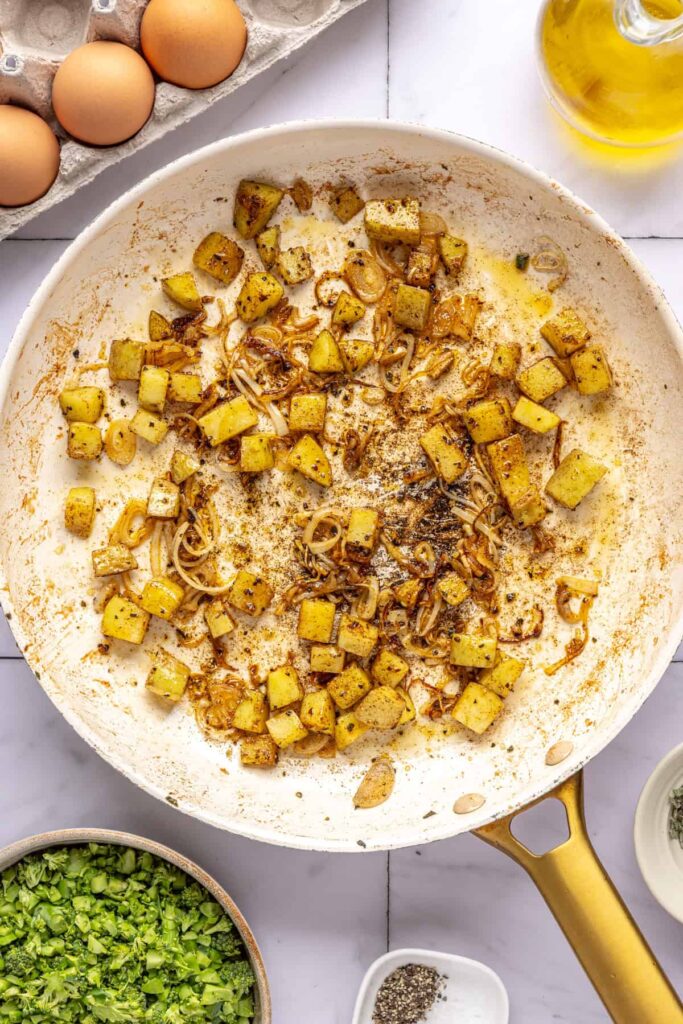 Veggies sautéing in skillet with seasonings for egg bake