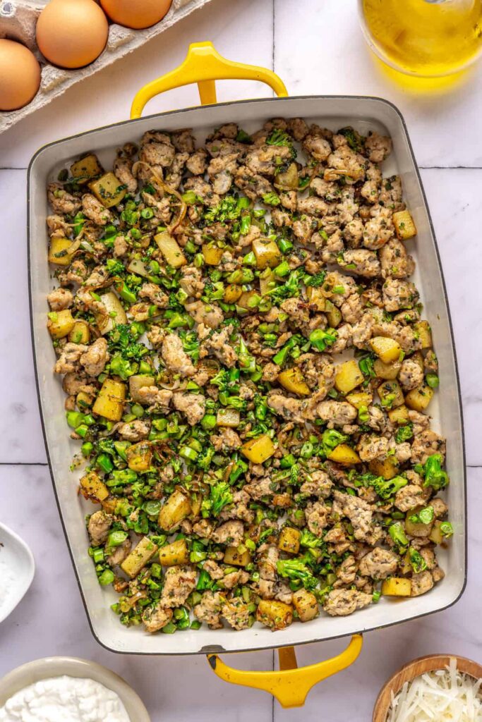 Overhead view of chicken sausage and prepped veggies and seasonings for Chicken & Veggie Egg Bake
