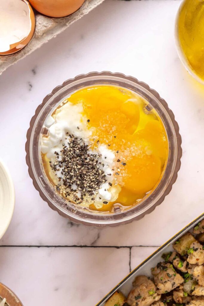 Ingredients for blended egg mixture for Chicken & Veggie Egg Bake, including eggs and cottage cheese, in a blender