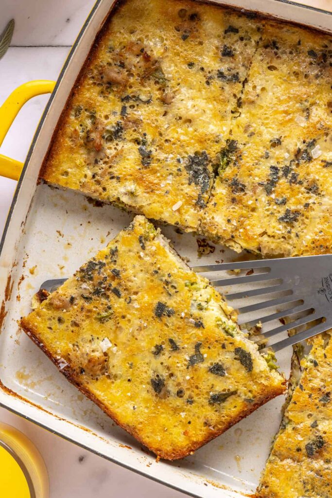 close-up of Slice of Chicken & Veggie Egg Bake being lifted from baking dish with a spatula