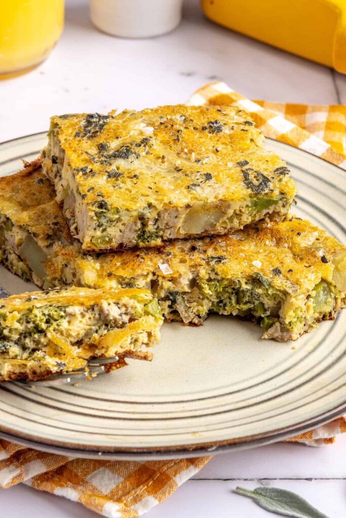 Side profile view of a slice of Chicken & Veggie Egg Bake showing layers of chicken, veggies, and eggs